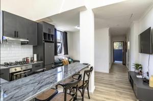 een keuken met een aanrecht en stoelen in een kamer bij CAPE20 Villa in Kaapstad