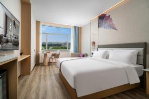 un grand lit blanc dans une chambre d'hôtel dans l'établissement eLong Hotel Suzhou Guanqian Street, à Suzhou