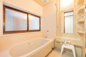 a bathroom with a tub and a sink and a window at 富士飛鳥 in Fujiyoshida