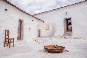 een stoel en een kom voor een gebouw bij Casa d'Aire in Porto de Mós