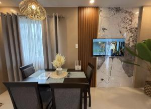a dining room with a table and a tv on a wall at Alpine Villas Greens Staycation at Crosswinds Tagaytay in Tagaytay +259 photos
