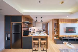 バンドンにあるSudirman Suites by Eazystayのバースツール付きの島のあるキッチン