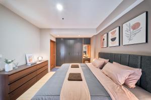 バンドンにあるSudirman Suites by Eazystayのピンクの枕が付いた大きなベッドのある寝室 +109枚の写真