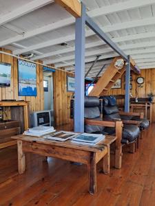 - un salon avec une table et des fauteuils en cuir dans l'établissement PS Federal Retreat Paddle Steamer Goolwa, à Goolwa