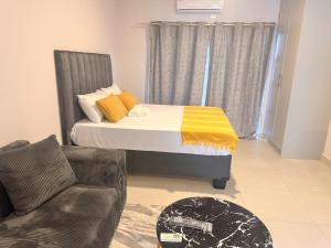 a bedroom with a bed and a couch at Stylish Studio Retreat in Gaborone +4 photos