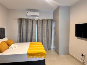 a bedroom with a bed with a yellow blanket on it at Stylish Studio Retreat in Gaborone
