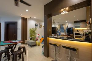 een keuken met een bar met krukken bij D'joysty in Johor Bahru