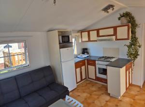 eine Küche mit einem Sofa und eine Küche mit einem Herd in der Unterkunft Mobil-home camping Le Ptit Rio in Noyelles-sur-Mer