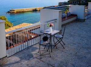 een tafel en stoelen op een balkon met uitzicht op de oceaan bij Exclusive B&B in Pizzo +37 foto's