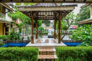 an entrance to a building with a wooden pergola at The Soemarsono Hotel near Ambarrukmo Plaza Mall RedPartner in Yogyakarta