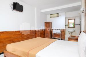 a bedroom with a bed and a sink at The Soemarsono Hotel near Ambarrukmo Plaza Mall RedPartner in Yogyakarta +9 photos
