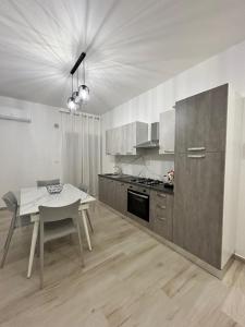 eine Küche mit einem Tisch und einem Tisch sowie ein Esszimmer in der Unterkunft La Casa di Giada in San Cataldo