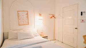 Un dormitorio blanco con una cama y una puerta. en Halaman Homestay, en Klang 14 fotos más