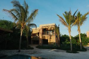 una casa vieja con dos palmeras delante en Kizikula, en Kizimkazi