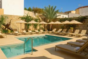 een zwembad met ligstoelen en parasols bij Hotel Boutique Petit París in Port de Pollença