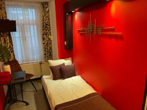 Una habitación roja con una cama y una pared roja. en Hotel Anco, en Ámsterdam
