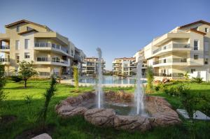 a fountain in a park in front of some buildings at Odyssey Park in Belek