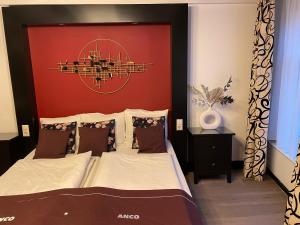 Un dormitorio con una cama grande con cabecero rojo. en Hotel Anco, en Ámsterdam 1 foto más