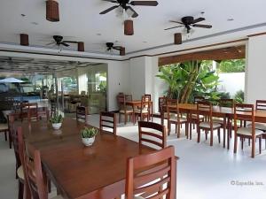 Puerto PrincesaにあるIpil Suites Puerto Princesaの大きな木製のテーブルと椅子のあるダイニングルーム