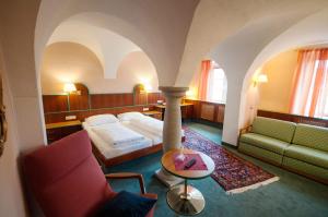 a hotel room with a bed and a couch and a table at Hotel Gasthof Sonne in Aschach an der Donau
