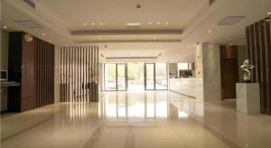 Una gran sala con un vestíbulo con paredes de cristal. en City Comfort Inn Wuhan High Speed Railway Station, en Wuhan