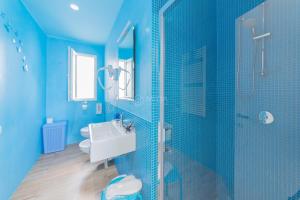 a blue bathroom with a sink and a shower at L'Ormeggio in Porto Cesareo +4 photos