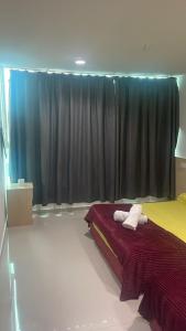 Batu Caves Paradise Hotel في بانيا إليجا: غرفة نوم بها سرير عليه منشفتان