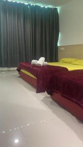 Batu Caves Paradise Hotel في بانيا إليجا: سريرين يجلسان بجانب بعضهما البعض في غرفة