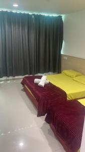 Batu Caves Paradise Hotel في بانيا إليجا: سريرين يجلسان بجانب بعضهما البعض في غرفة