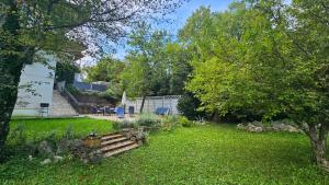 a yard with a wooden bench in the grass at Nia Apartment in Jadranovo