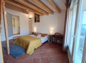 een slaapkamer met een bed, een tafel en een raam bij Charmante Maison De Village 60 M² in Mollans-sur-Ouvèze