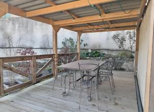 een terras met een tafel en stoelen op een dek bij Charmante Maison De Village 60 M² in Mollans-sur-Ouvèze