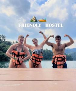 um grupo de pessoas em pé em uma doca na água em Friendlyhostel em Khao Sok