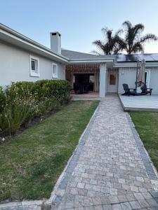 a house with a brick walkway in the yard at 1 Diadem in Plettenberg Bay
