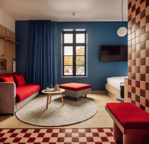 a living room with a red couch and a bed at Hobo Oslo in Oslo