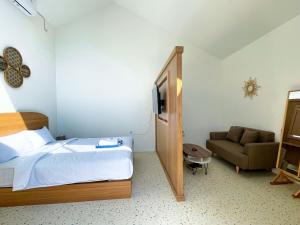 ein Hotelzimmer mit einem Bett und einer Couch in der Unterkunft Oasis Montana Jogja in Ngemplak