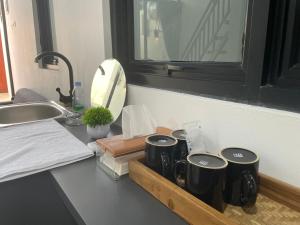 eine Küchentheke mit drei Kaffeetassen auf einem Tablett in der Unterkunft Oasis Montana Jogja in Ngemplak