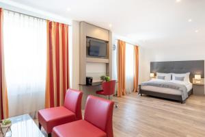 una camera d'albergo con un letto e due sedie rosse di Garner Hotel Stuhr - Bremen A1 by IHG a Stuhr Altre 31 foto