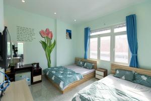 ein Schlafzimmer mit zwei Betten und einer Blumenvase in der Unterkunft Dalat House in Vũng Tàu