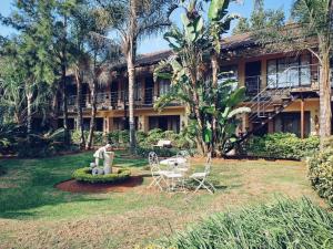 a building with a fountain and chairs in a yard at Lakefield Hotel in Benoni