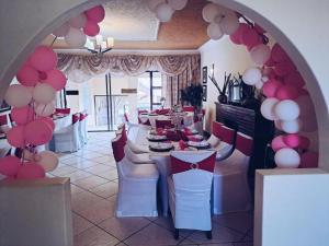a dining room with a table with pink and white balloons at Lakefield Hotel in Benoni +6 photos