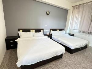 una camera da letto con due letti con lenzuola bianche e una finestra di 香菇里啦 a An-ch'i Altre 8 foto