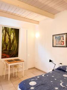 フォルリにあるPorta Merlonia houseのベッドルーム1室(ベッド1台、テーブル、絵画付)