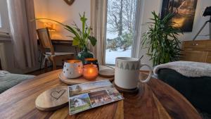 a wooden table with mugs on it in a living room at Ferienwohnung Fichtelsonne in Fichtelberg