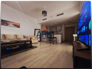 ein Wohnzimmer mit Sofa und Fernseher in der Unterkunft ARK Luxury Rooms walking Distance to Ferrari world, Yas Island in Yas Island