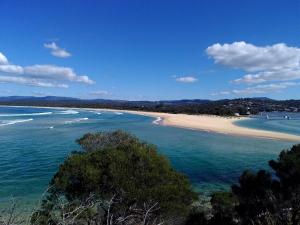 a sandy beach with a view of the ocean at Como Lodge in Merimbula