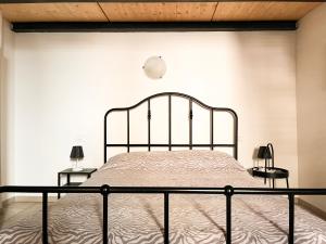 フォルリにあるPorta Merlonia houseのベッド1台(ナイトスタンド2台、ランプ2つ付)が備わる白い部屋