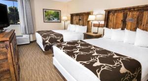 a hotel room with two beds and a flat screen tv at Days Inn Springfield South in Springfield +88 photos