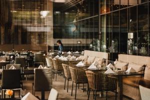 Una mujer caminando por un restaurante con mesas y sillas. en Strömstad Spa & Resort, en Strömstad