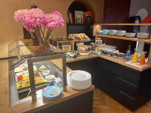 Ein Buffet mit rosa Blumen und Tellern auf einer Theke in der Unterkunft HeiMaT Häusle - Heike Marcus Tiny-houses in Cleebronn